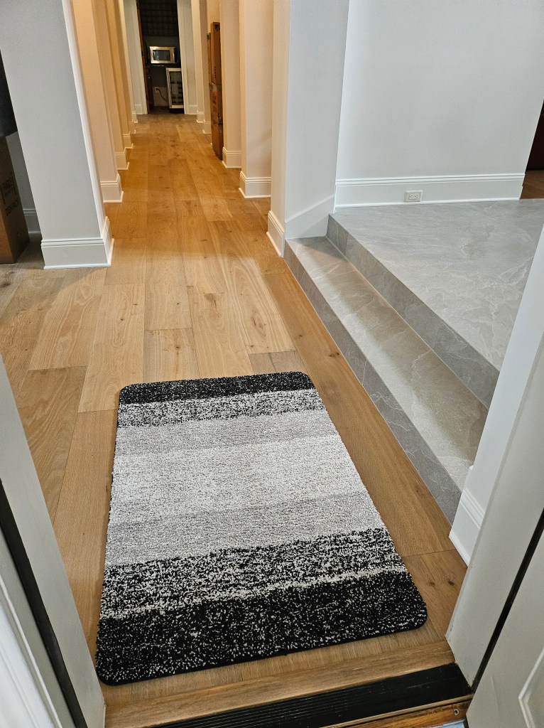 Here is the rewritten caption, reduced to 120 words: The image depicts a long hallway with a door at the bottom and a hall...